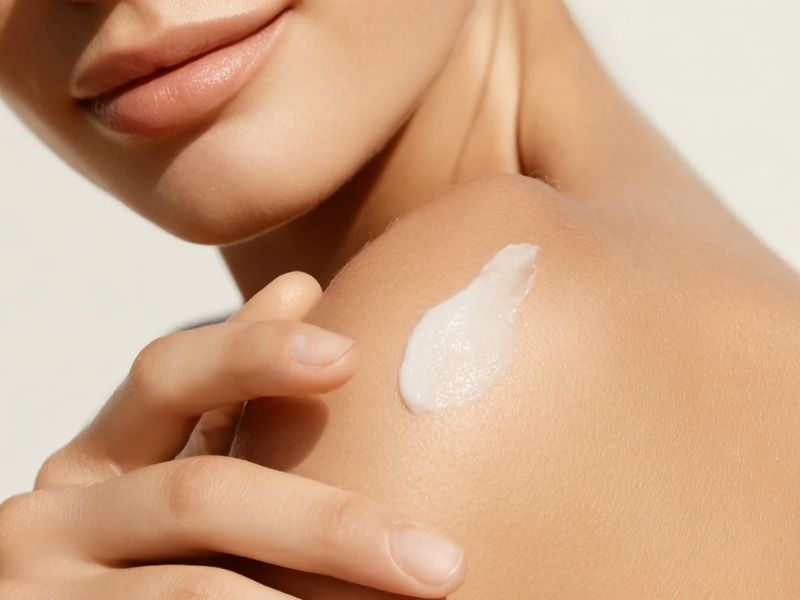 devojka maže kremu na svoje rame